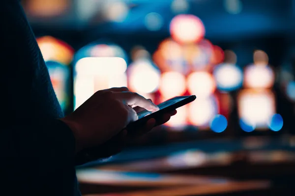 A stylish woman beside vibrant slot machines displaying glowing sevens, showcasing the variety of top slots at ZBZBED.