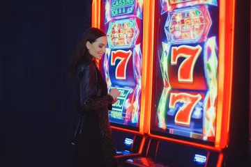 A man celebrating a winning moment on his laptop while gaming symbols float around him, capturing the excitement of ZBZBED games.