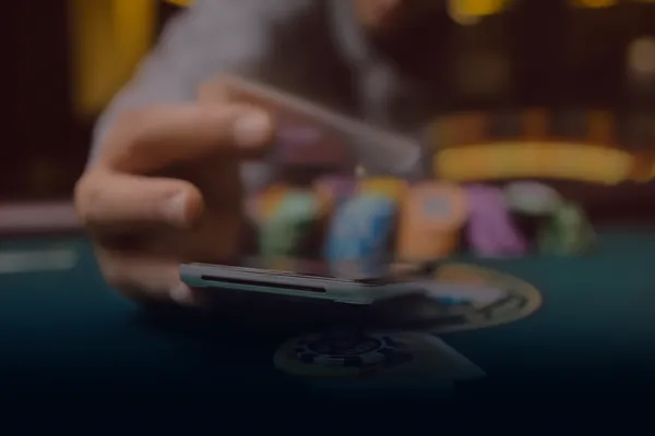 A person using their device against a moody casino-themed background, illustrating the smooth re-entry process at ZBZBED.